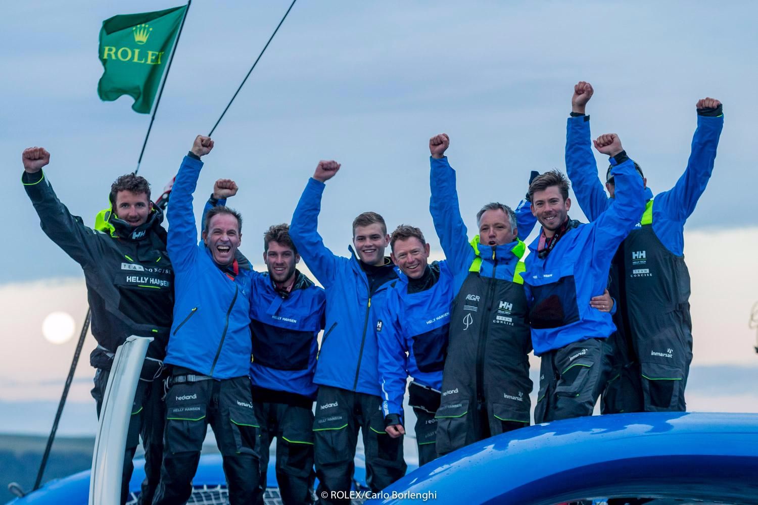 The crew of Concise 10, the MOD70, celebrate at the finish of the Rolex Fastnet Race. Credit: ROLEX/Carlo Borlenghi